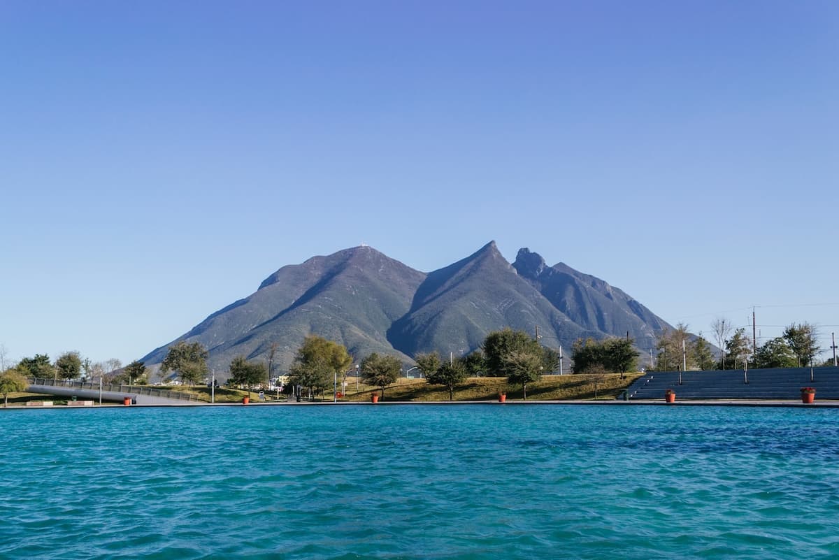 Paisaje montañoso con un lago, representando el compromiso de MMTubería con proyectos en entornos naturales.