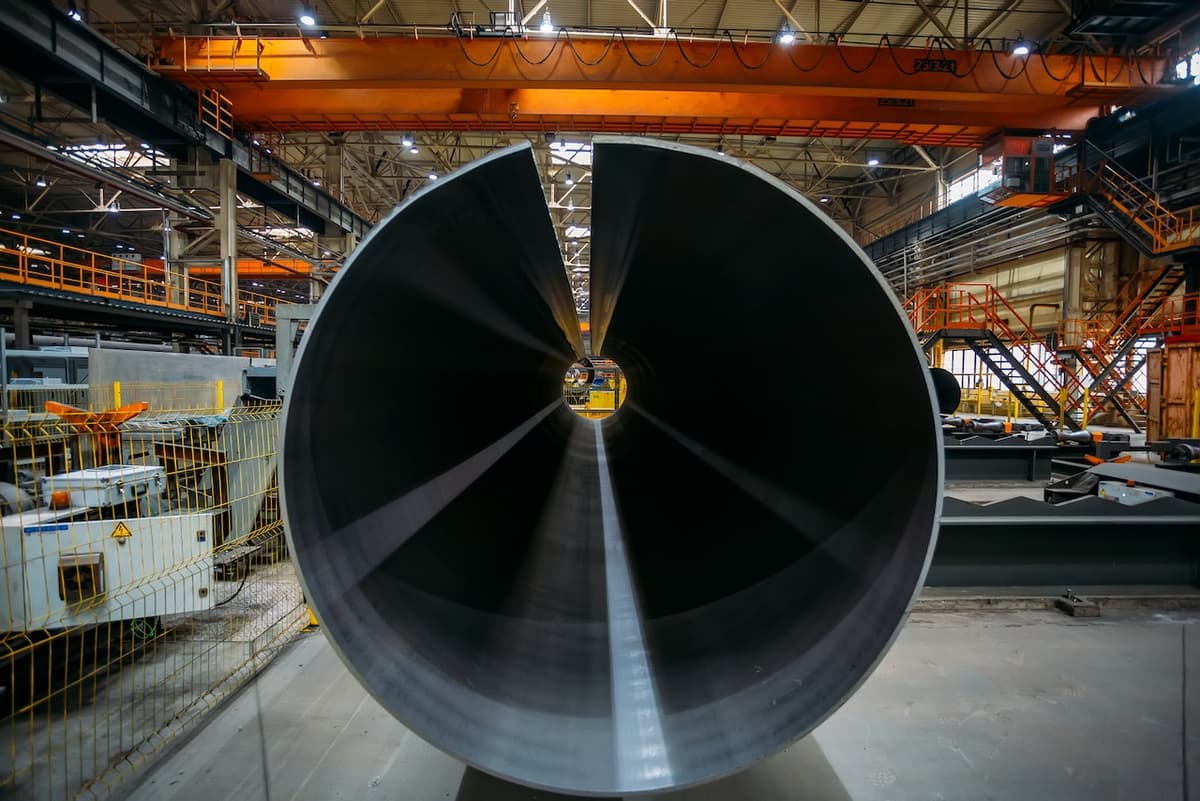 Tubería de acero de gran diámetro en proceso de revisión, resaltando el compromiso de MMTubería con la calidad y precisión en sus productos.