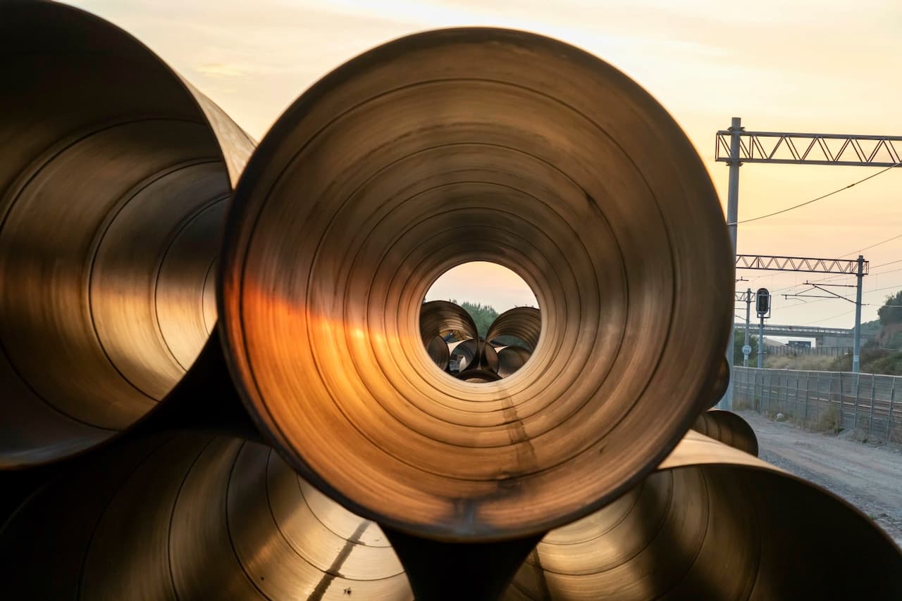 Vista a través de un conjunto de tubos de acero al carbón apilados, destacando la calidad del material.