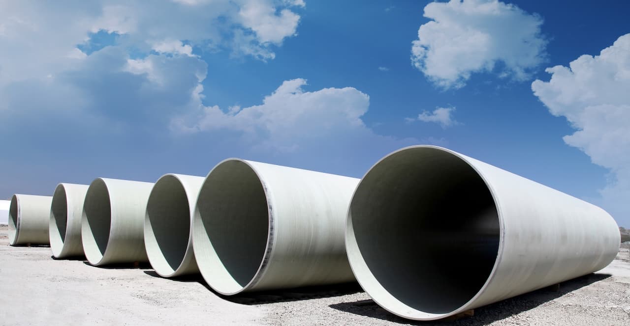 Dos tuberías de gran diámetro contra un cielo nublado, simbolizando la grandeza y capacidad de los sistemas de tuberías para proyectos de gran escala.