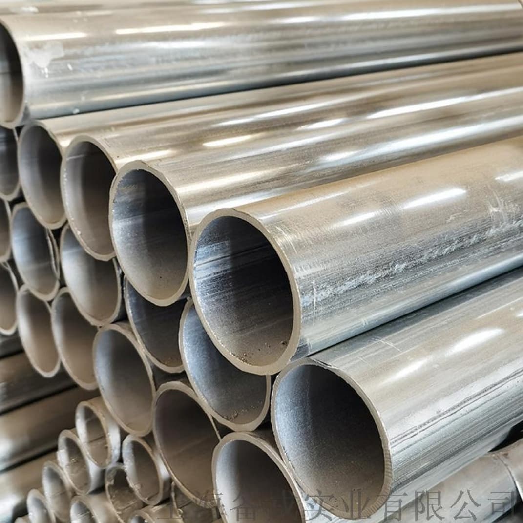 Fila de tuberías de acero con acabado brillante, reflejando la luz en un entorno industrial, destacando su durabilidad y calidad superior.