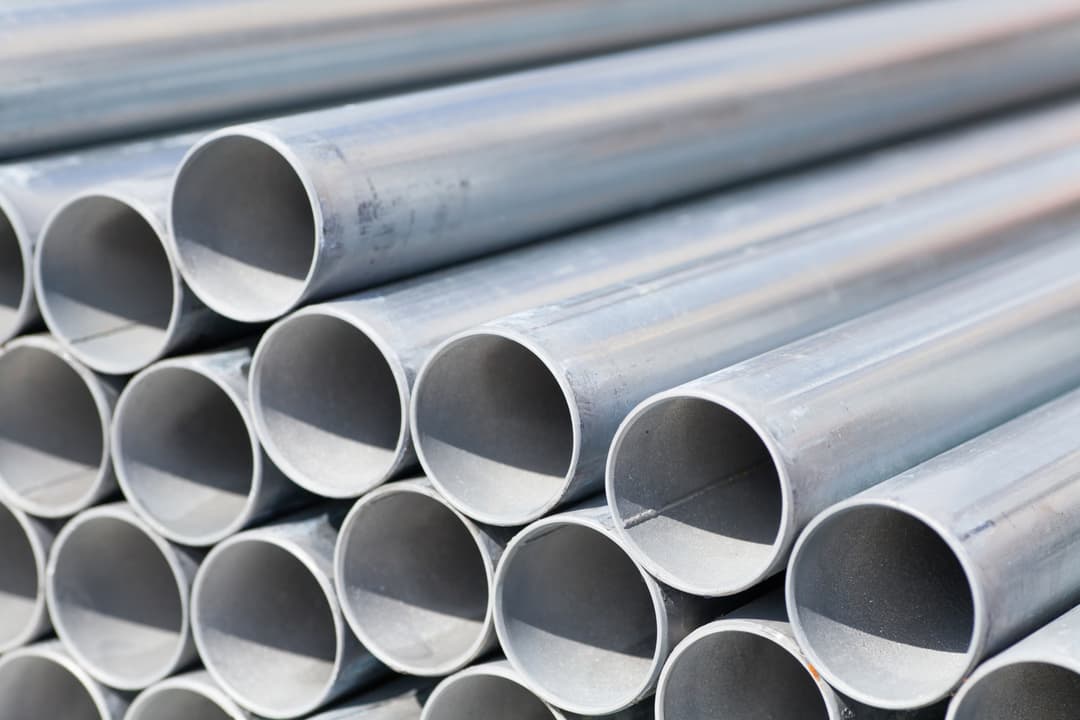 Vista aérea de una ciudad al atardecer, mostrando un río que atraviesa entre complejos urbanos, simbolizando el alcance de MMTubería en proyectos de gran envergadura a nivel nacional.