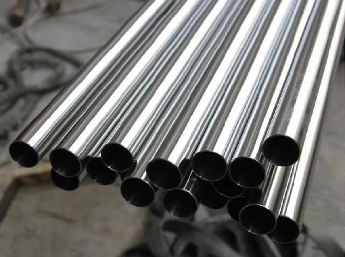 Pila de tuberías de acero almacenadas verticalmente, mostrando la uniformidad y el brillo del acero inoxidable listo para su distribución.