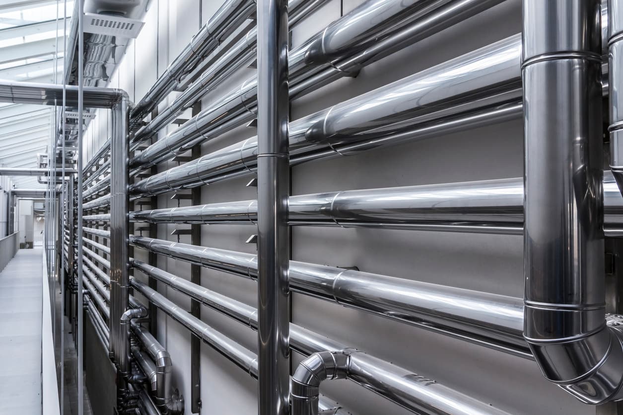 Sistema organizado de tuberías de acero en una instalación industrial, mostrando una infraestructura limpia y ordenada, esencial para procesos eficientes.