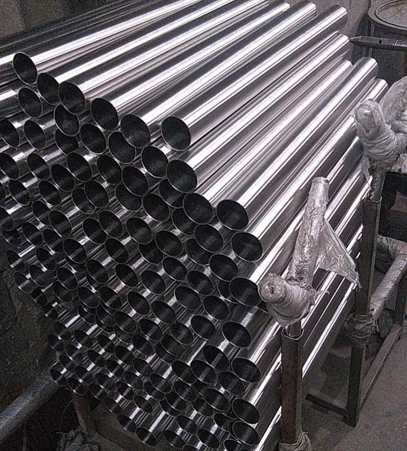 Apilamiento de tuberías de acero en un almacén, destacando la disposición y la preparación para su uso en proyectos de infraestructura y construcción.