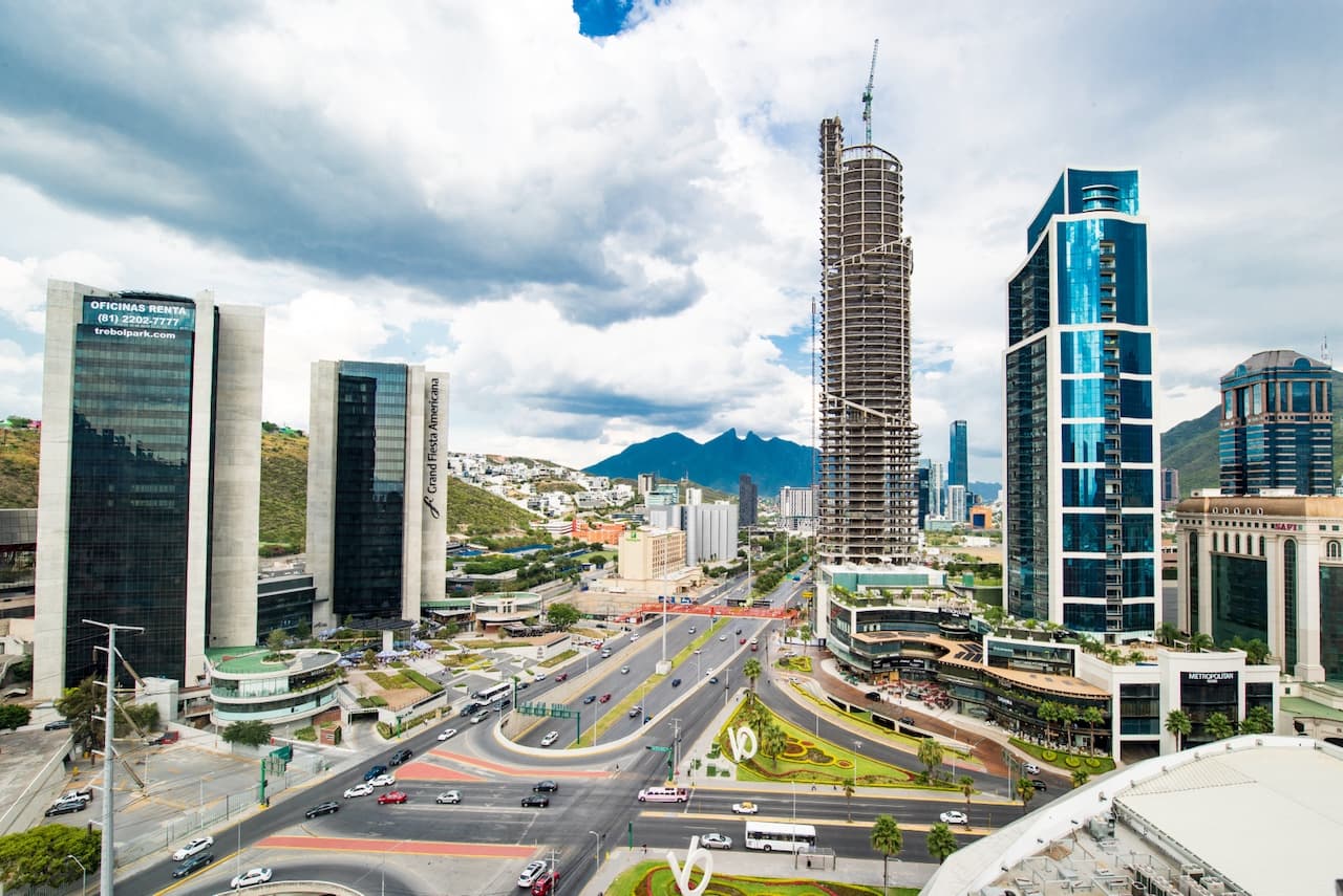 Vista aérea de Monterrey con edificios en construcción y modernas avenidas, simbolizando el impacto de MMTubería en el desarrollo urbano y la construcción de infraestructura crítica.