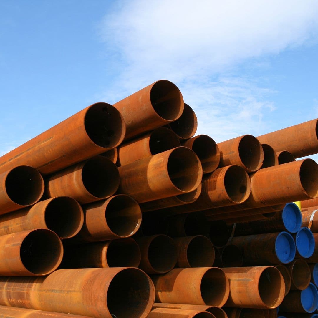 Tubería de acero con revestimiento oxidado en un entorno natural, demostrando durabilidad y resistencia a la corrosión en condiciones adversas.