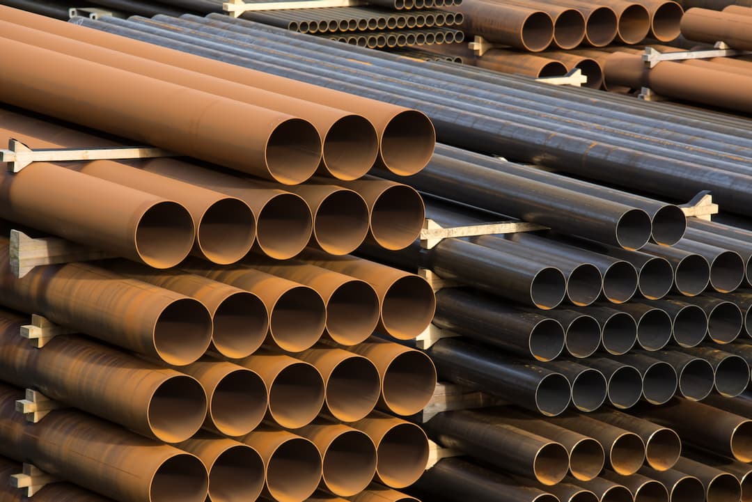 Vista de tuberías de acero almacenadas en grandes cantidades, listas para ser distribuidas y utilizadas en proyectos de construcción e infraestructura.