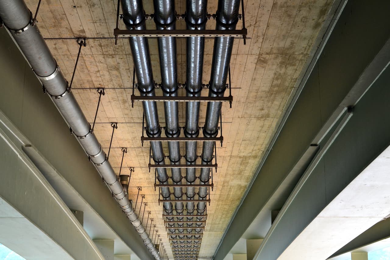 Vista de un sistema de tuberías instalado bajo una estructura de concreto, mostrando la durabilidad y el diseño eficiente en los proyectos industriales suministrados por MMTubería.