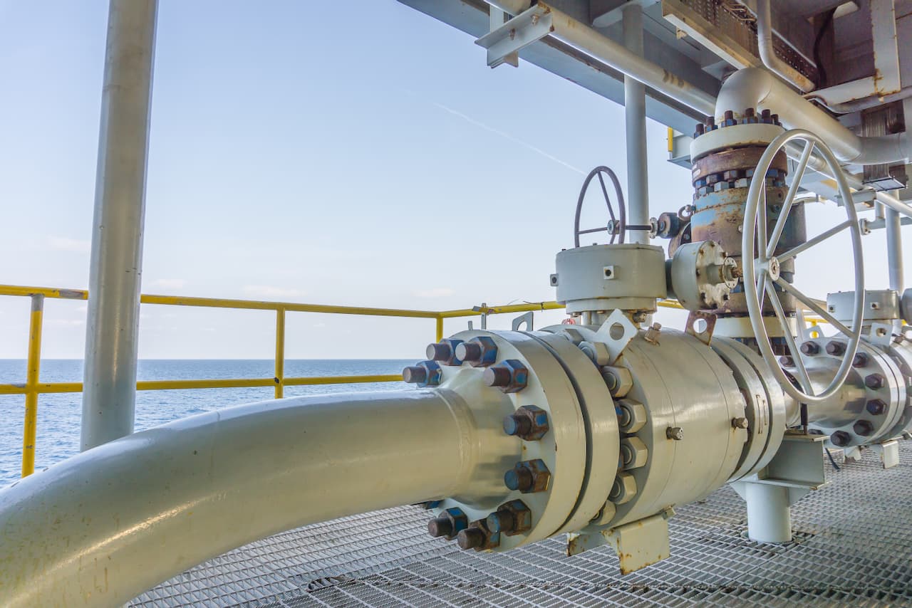 Conexión de tubería industrial en una plataforma frente al mar, mostrando la durabilidad y alta calidad de los productos de MMTubería en entornos marítimos.